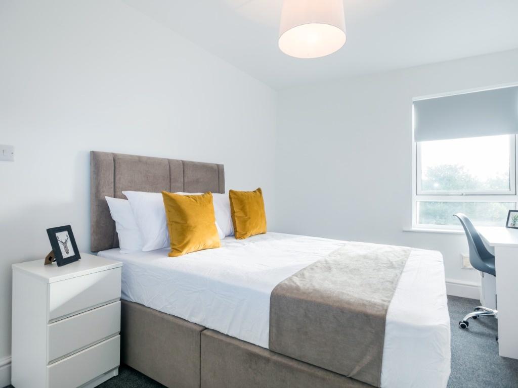 Bright modern bedroom with cosy bed and desk...