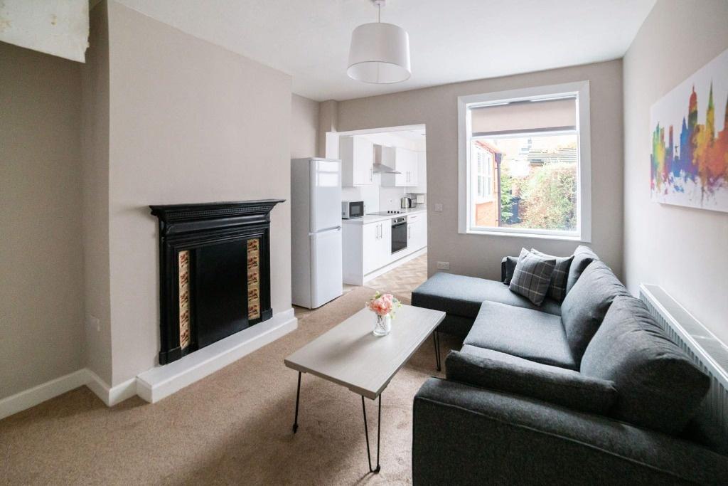 Bright furnished lounge with sofa and fireplace...