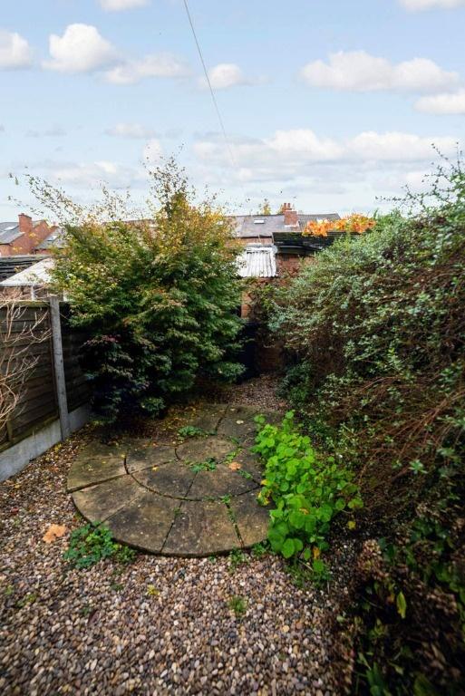 Low-maintenance garden with paved seating area...