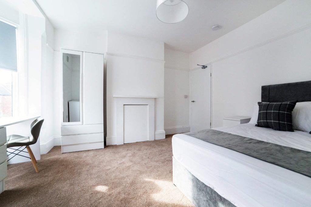Bright bedroom with large window and study area...