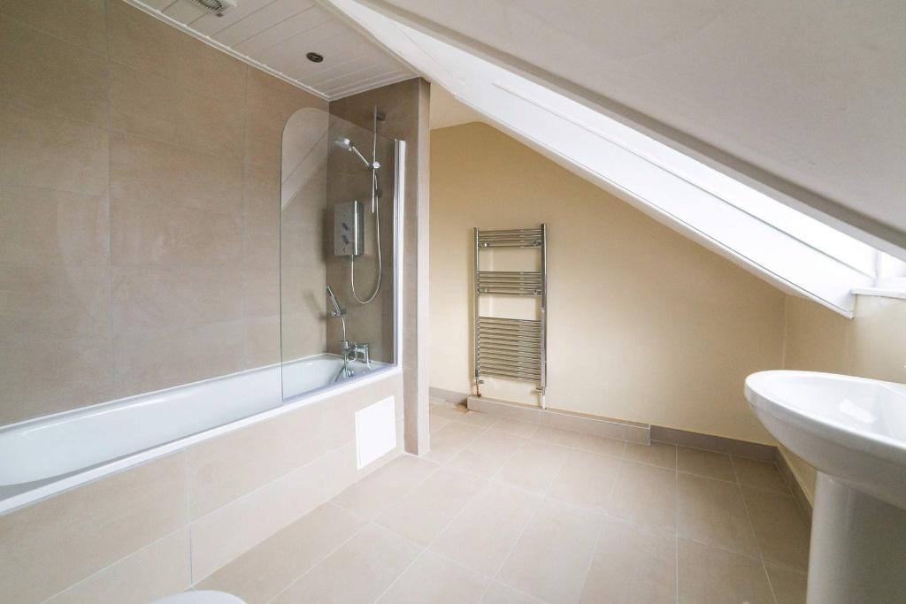 Bright modern bathroom with bath and skylight...