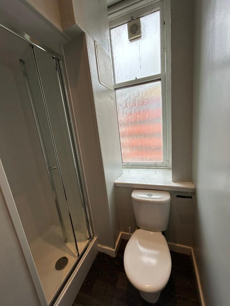 Compact bathroom with shower and window...
