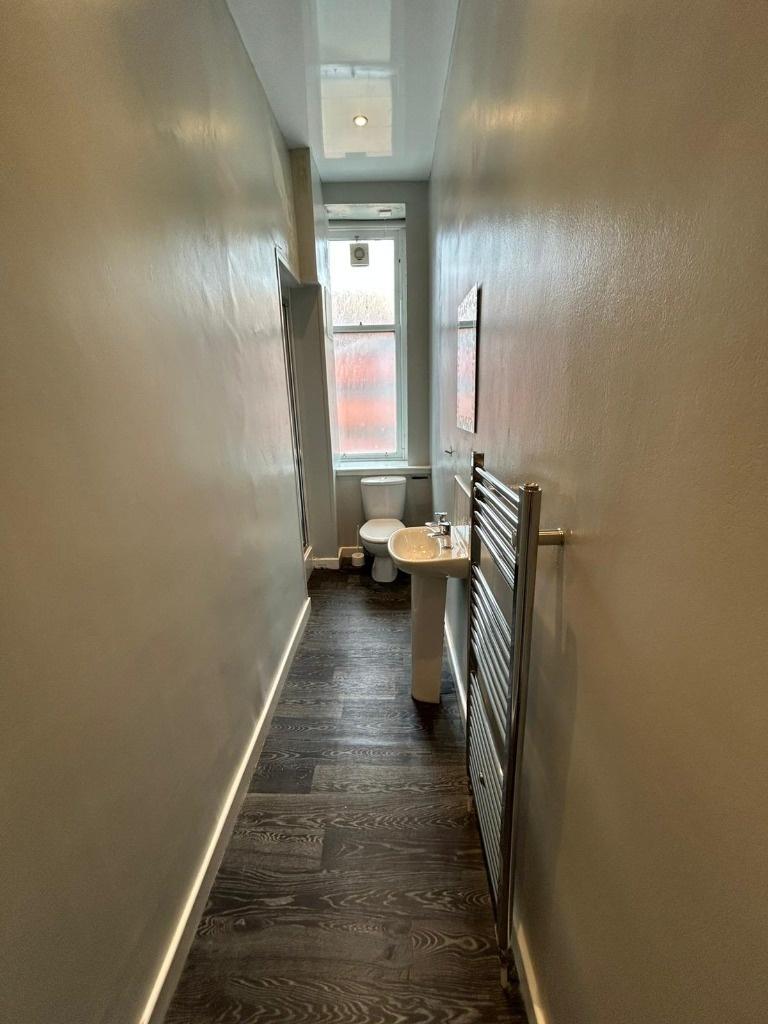 Narrow hallway with natural light and wood-look...