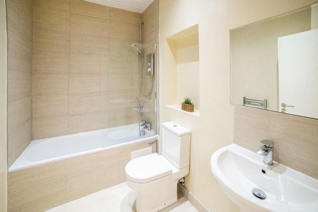 Bright modern bathroom with bath and clean fini...