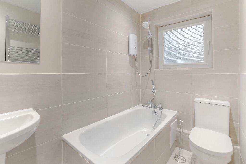 Bright modern bathroom with bathtub and shower...