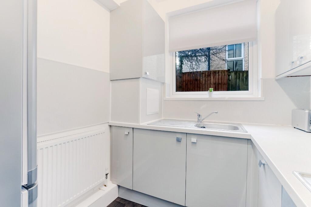 Bright white kitchenette with neat surfaces...