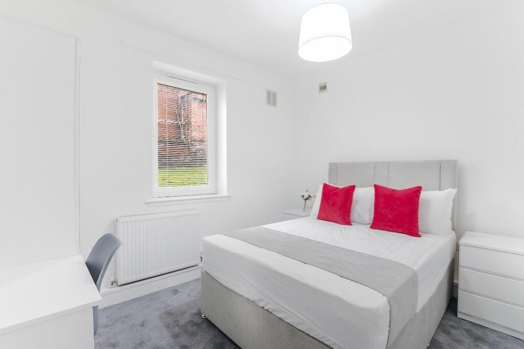 Bright, modern bedroom with desk and storage...