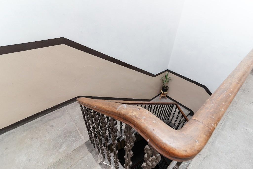 Bright, well-kept staircase with wooden baniste...