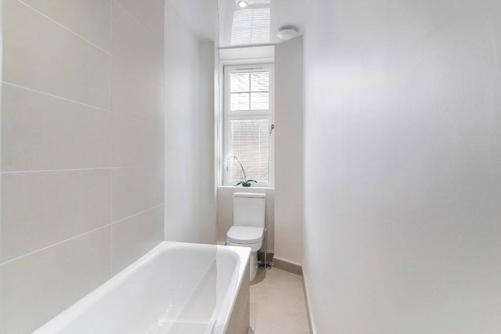 Bright bathroom with bathtub and window...