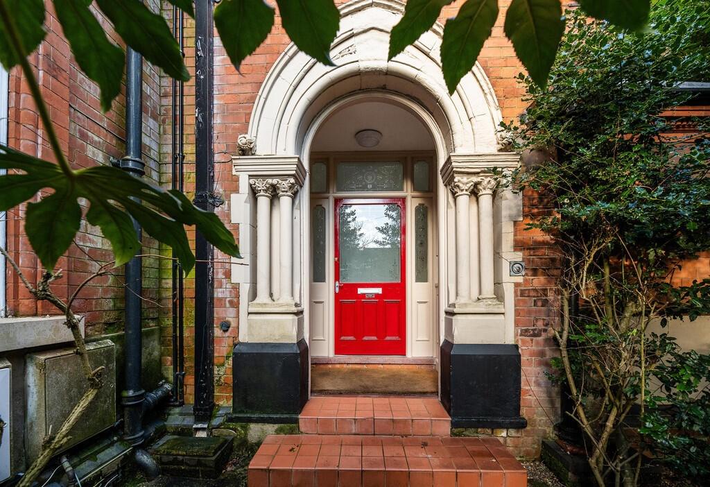 Attractive red-door entrance with classical por...