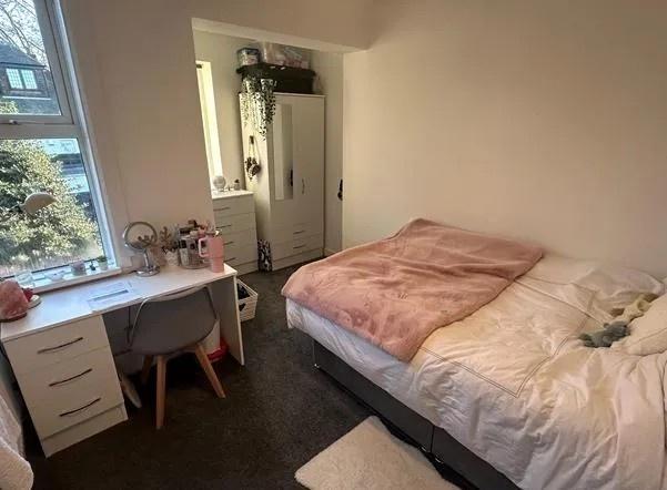 Bright furnished bedroom with desk and storage...