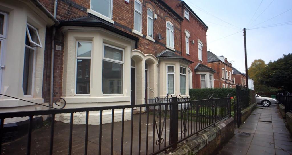 Terraced brick facade with bay windows and rail...