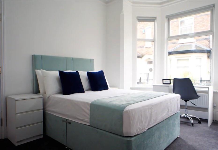 Bright, modern bedroom with desk and bay window...