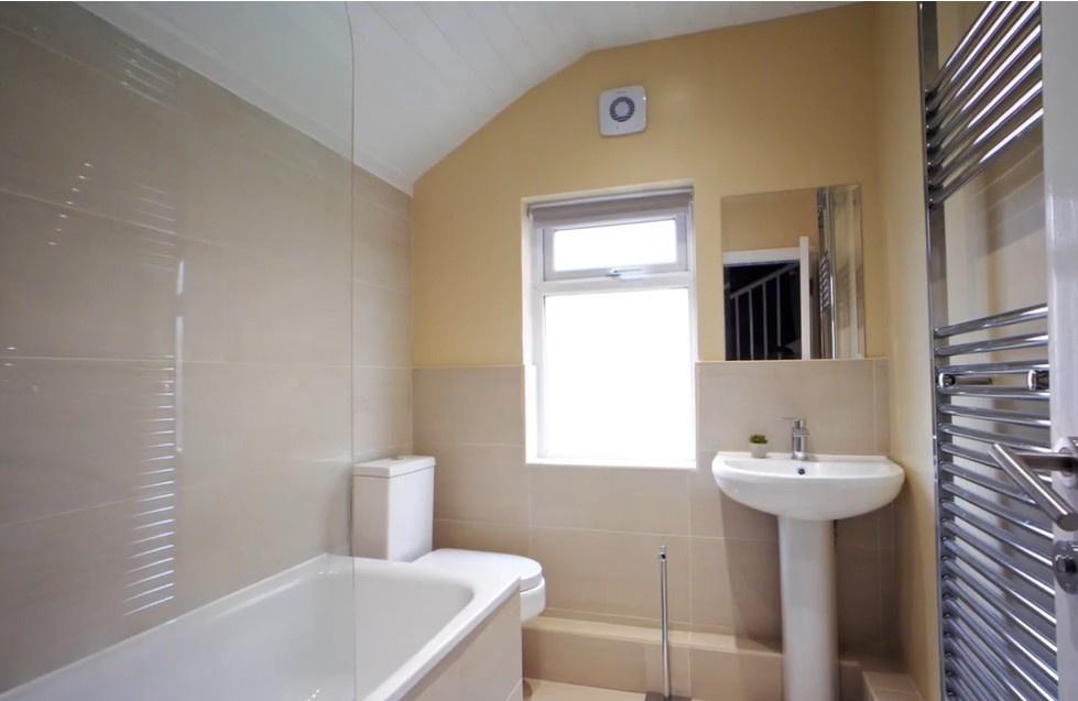 Bright bathroom with bathtub and heated towel r...