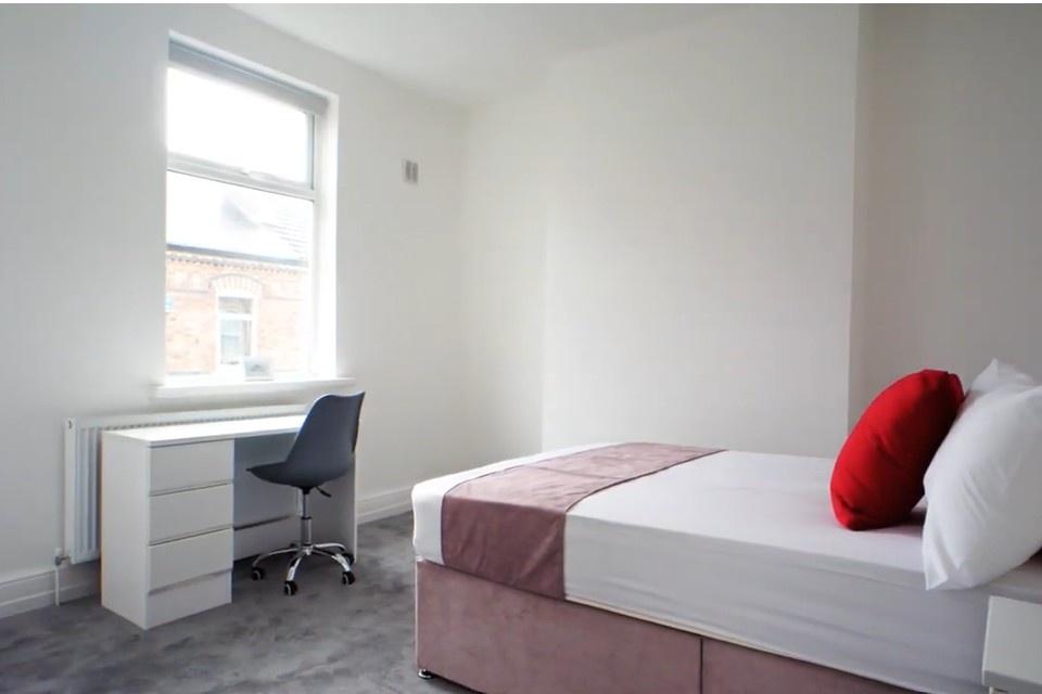 Bright, tidy bedroom with desk and comfortable ...