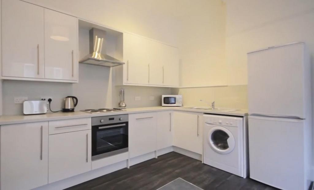 Bright modern white kitchen with appliances...