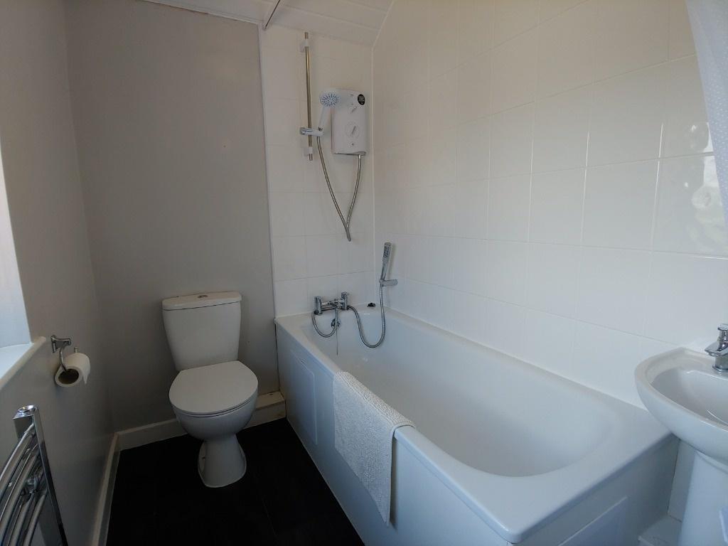 Bright, clean bathroom with bath and toilet...