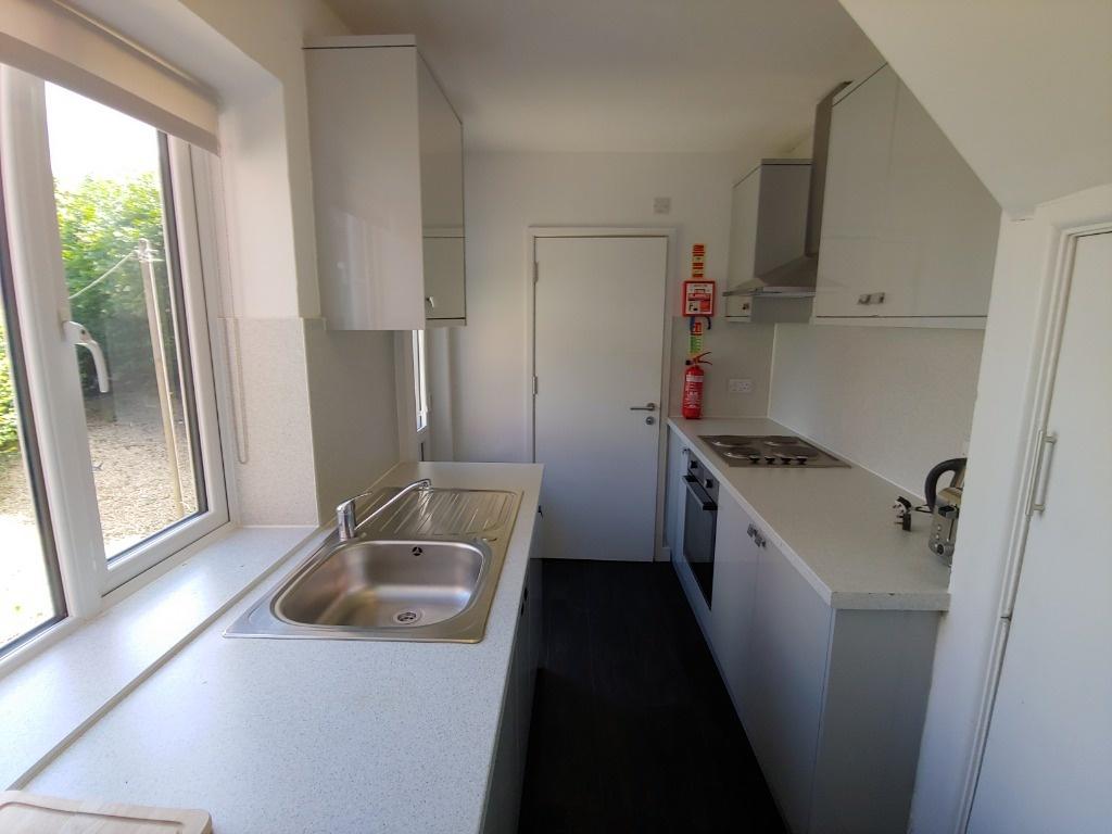 Bright galley kitchen with modern white units...