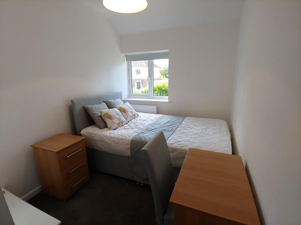 Bright furnished double bedroom with bedside ta...