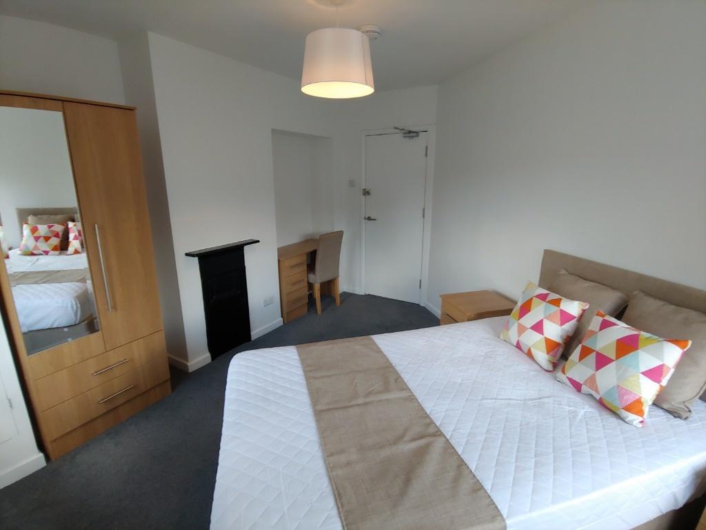 Bright double bedroom with wardrobe and firepla...