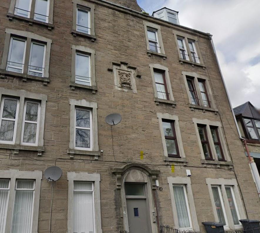 Traditional sandstone building with tall window...