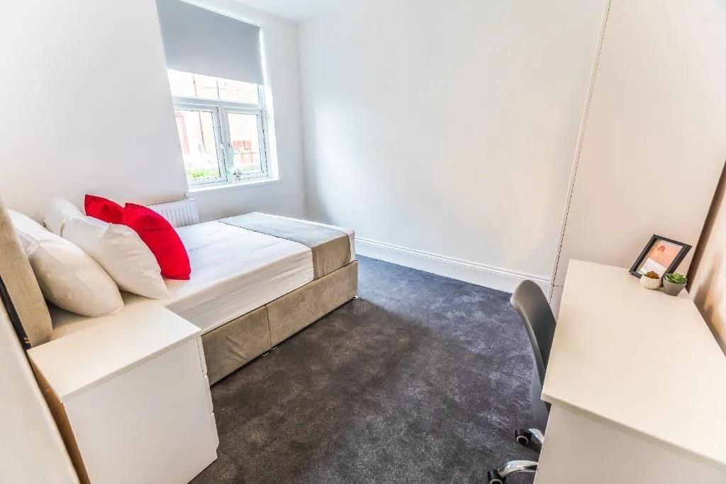Bright, neat bedroom with desk and storage...