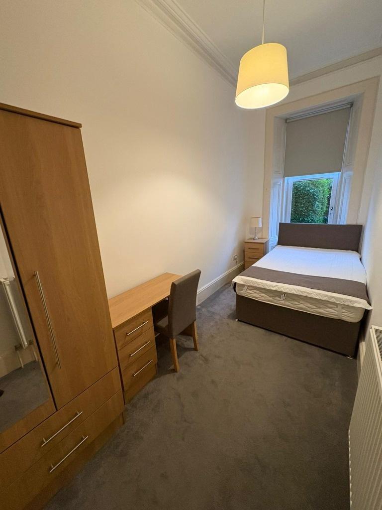 Neat furnished bedroom with desk and wardrobe...