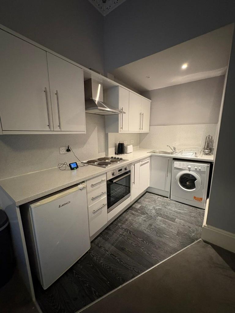Modern white fitted kitchen with appliances...