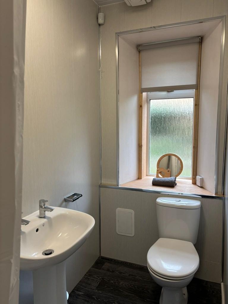 Compact bathroom with window and pedestal sink...