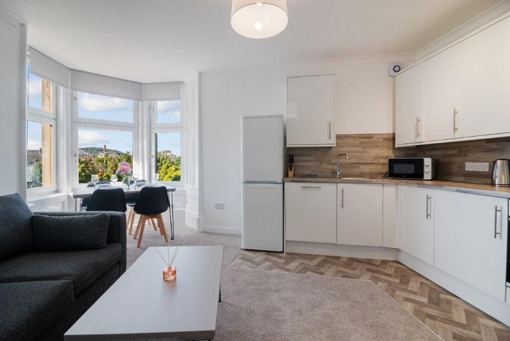 Bright open-plan living area with bay window...