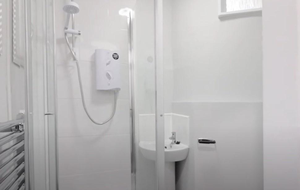 Clean white shower room with sink...
