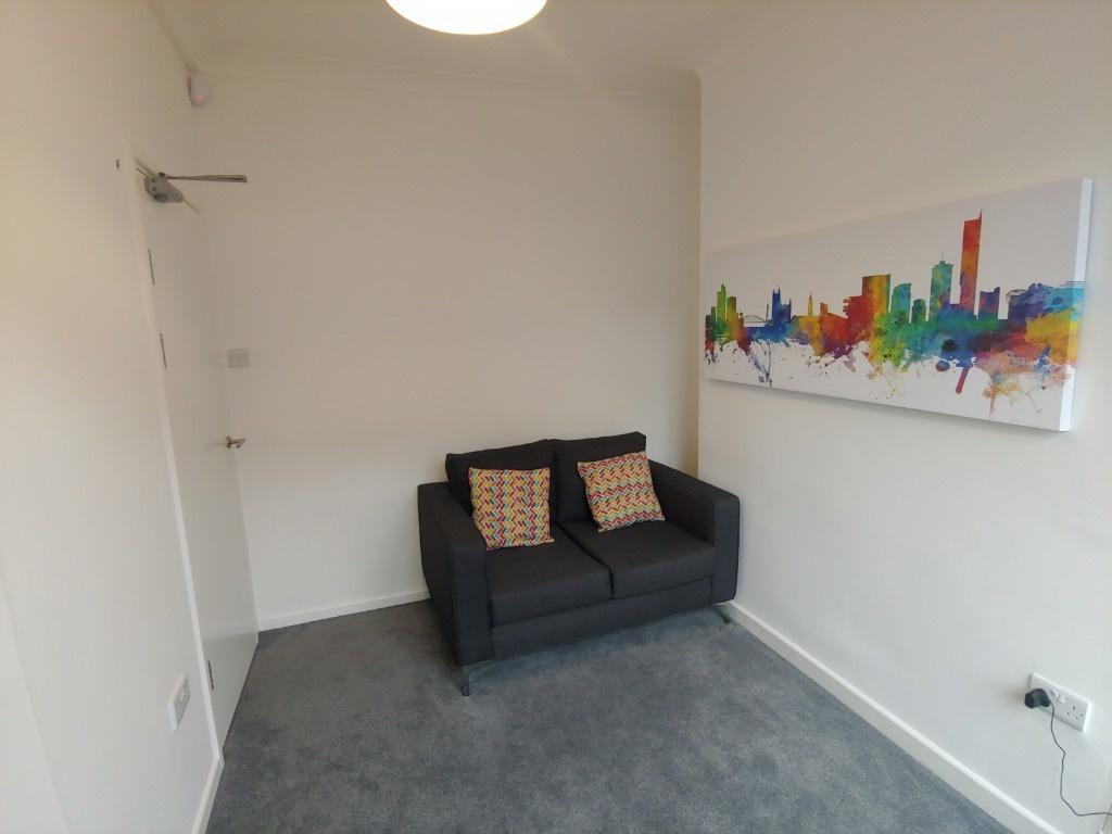 Neat lounge with sofa and colourful wall art...