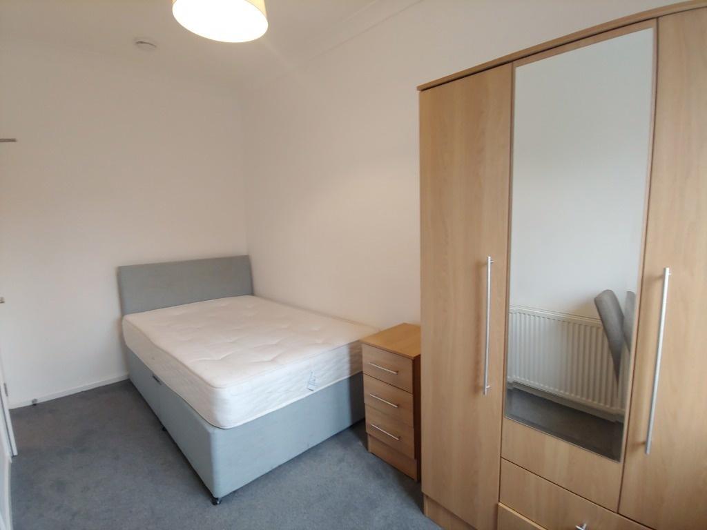 Bright furnished bedroom with wardrobe and bed...