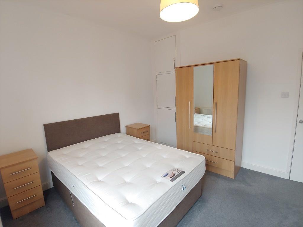 Bright bedroom with double bed and storage...