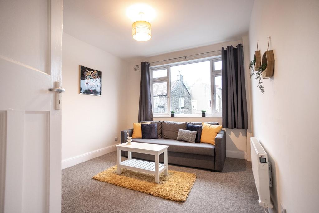 Bright, neatly presented living room with a lar...