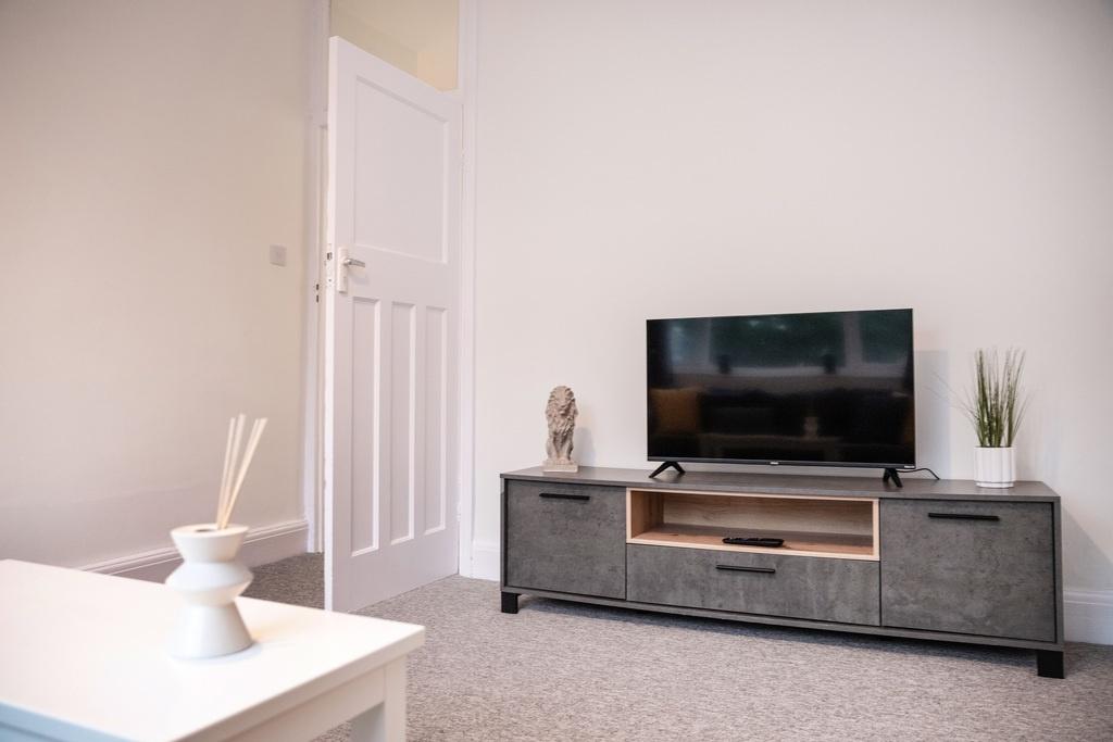 Bright, neutral living area with a modern media...