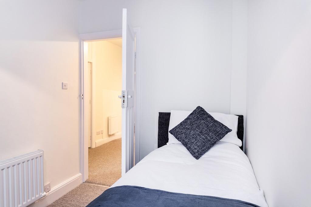 Neat single bedroom with a tidy made bed, neutr...