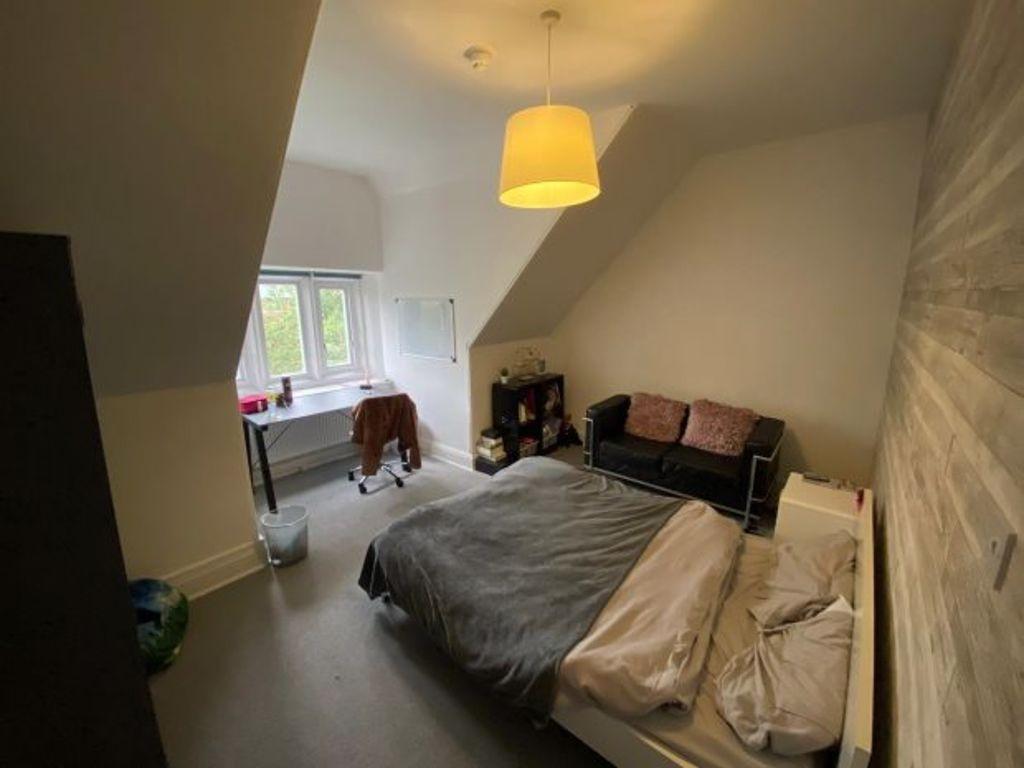 A well-lit bedroom featuring a double bed with ...