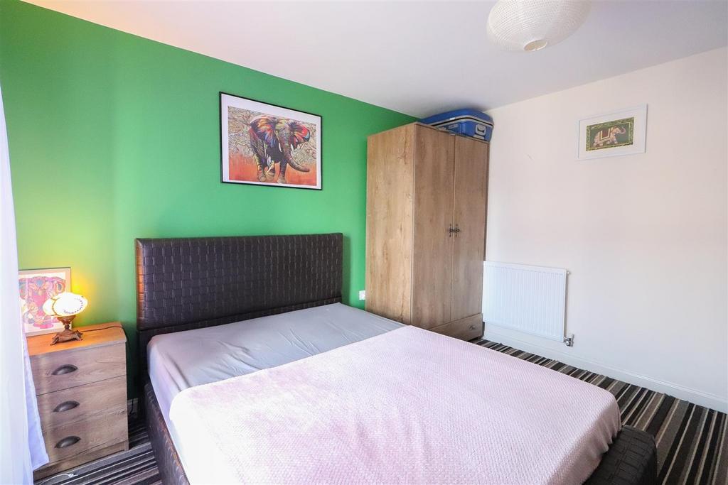 Bright bedroom with colorful feature wall and b...