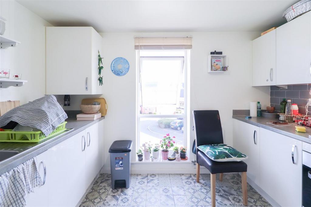Bright kitchen with white units and natural lig...