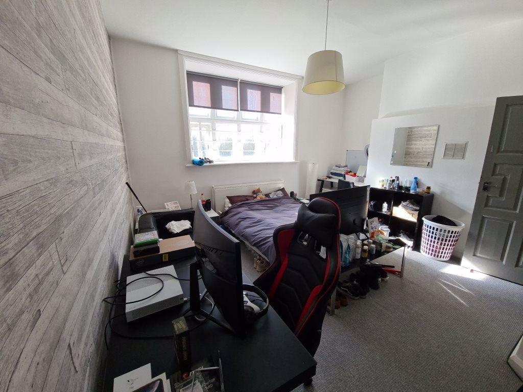 A cozy bedroom featuring a double bed, a desk w...