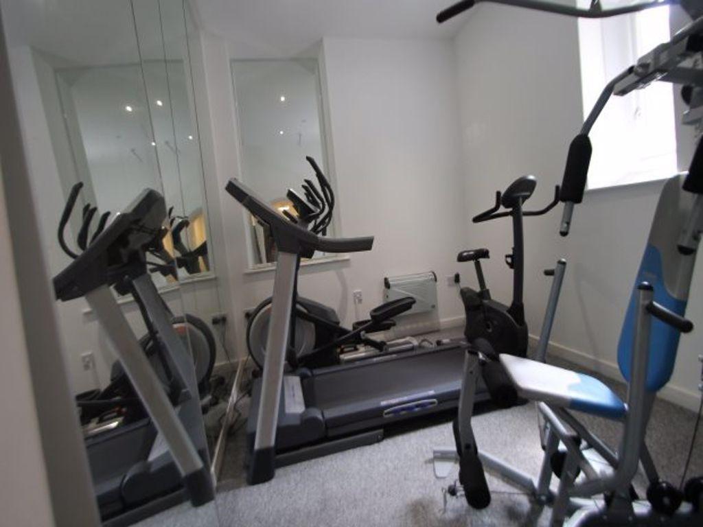 A dedicated gym area equipped with exercise mac...