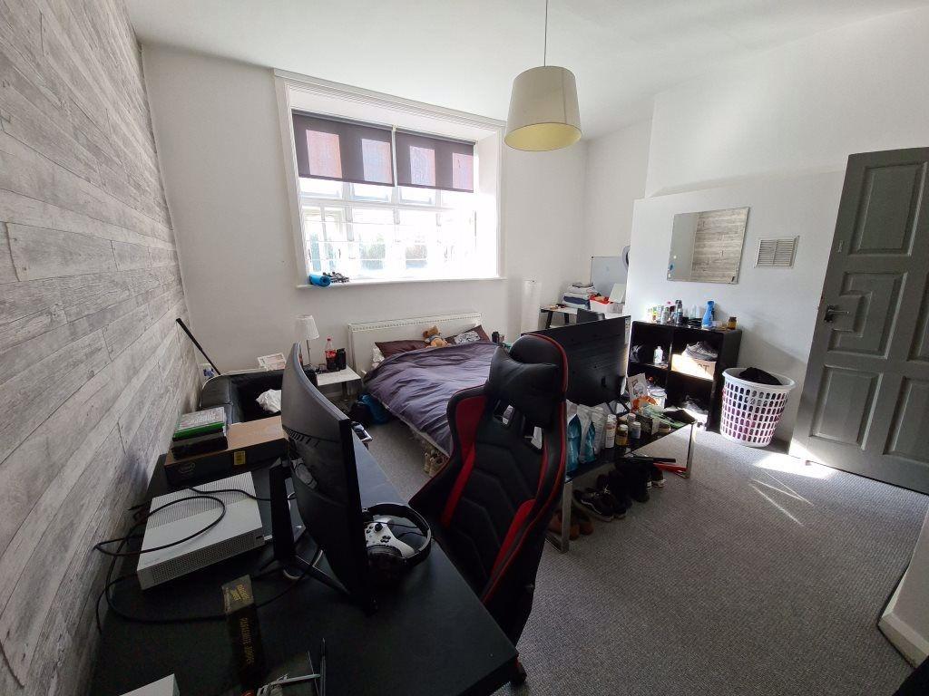 A cozy bedroom featuring a bed, desk, and wardr...