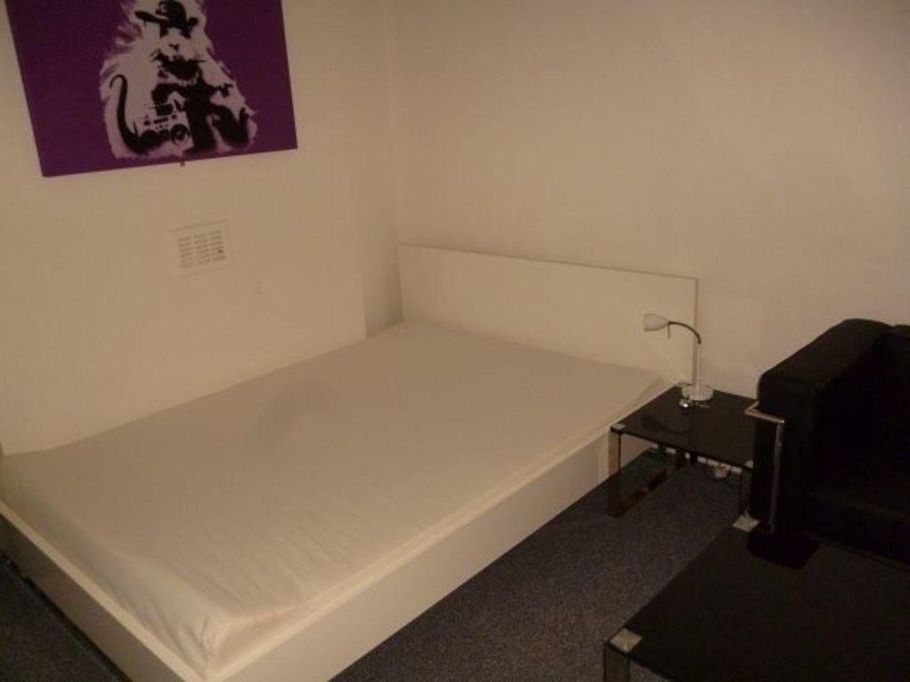 A tidy single bedroom featuring a comfortable b...