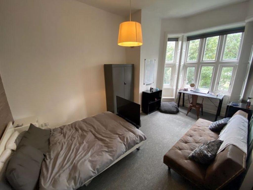 A spacious and inviting bedroom featuring a lar...
