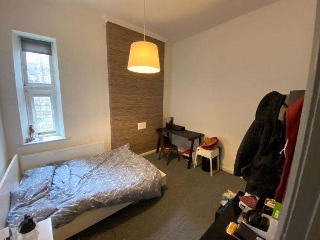 A cozy single bedroom featuring a neatly made b...