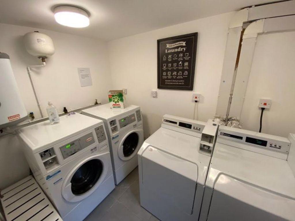 Well-equipped and tidy laundry room featuring m...