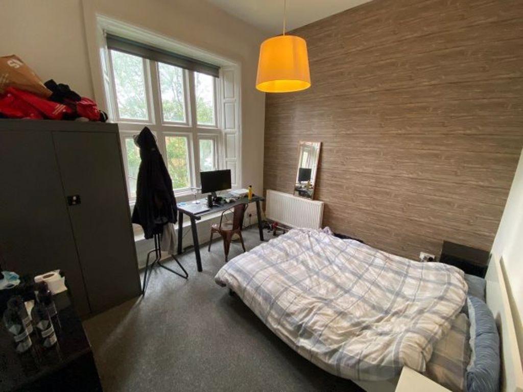 A cozy and well-lit bedroom featuring a comfort...