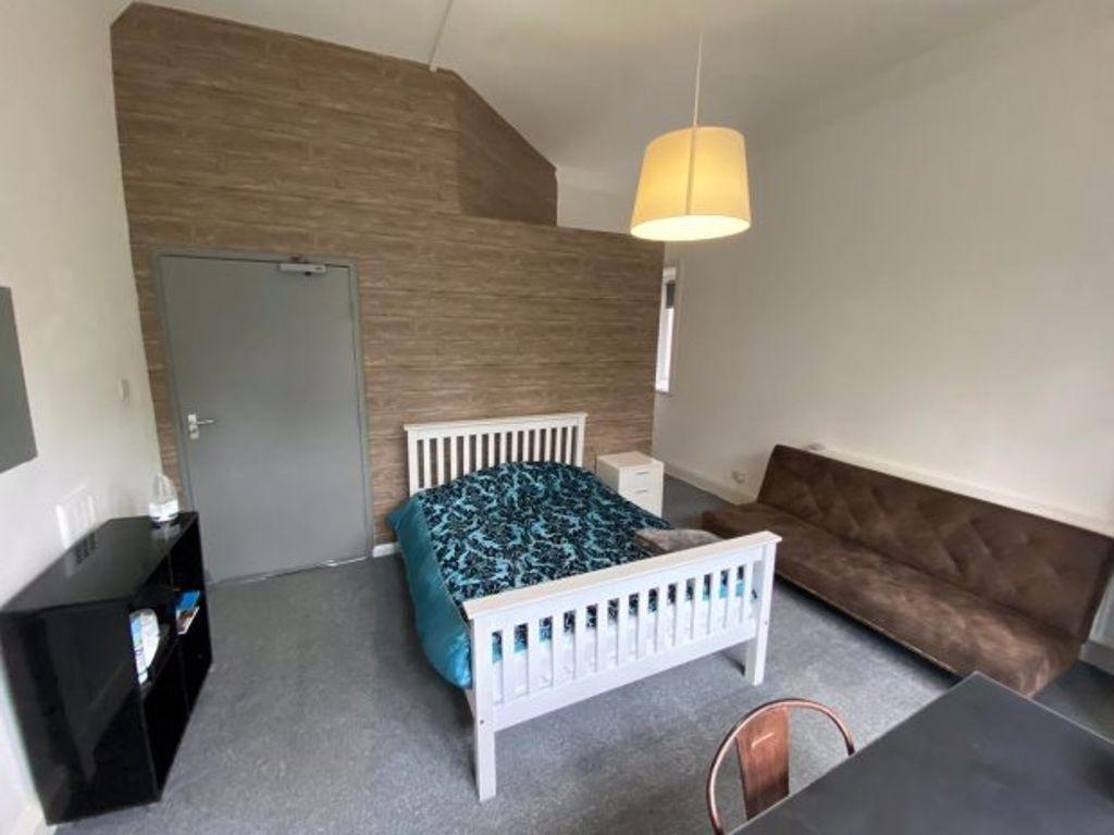 A clean and cozy double bedroom featuring a whi...