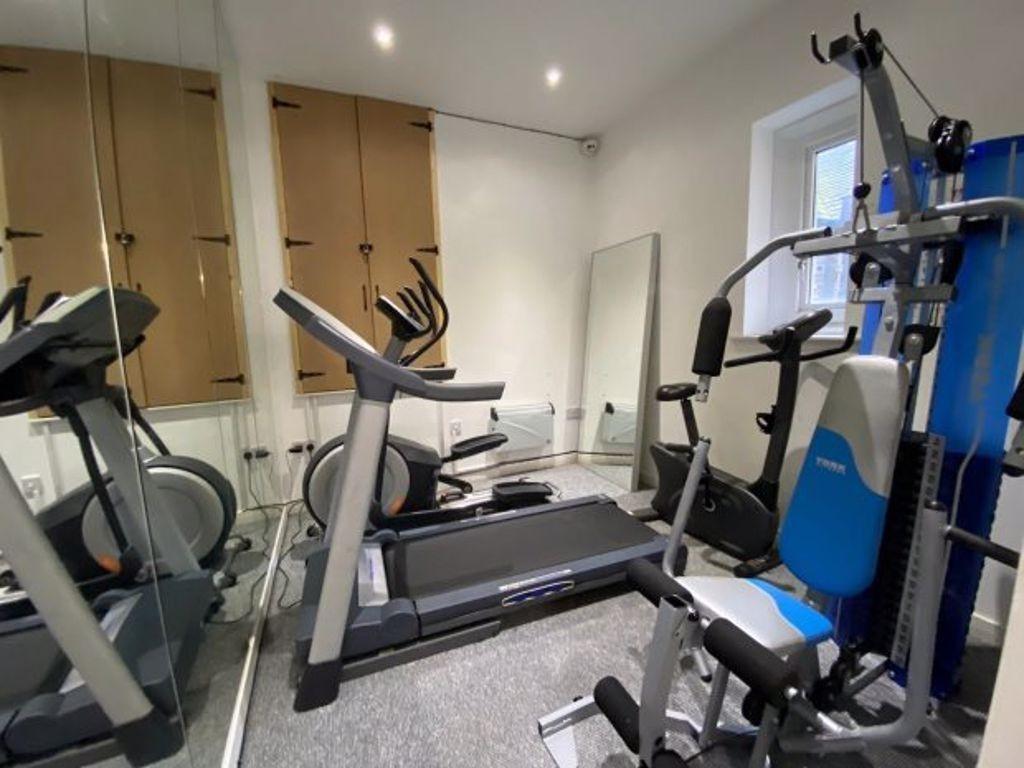 Well-equipped and tidy gym room featuring moder...